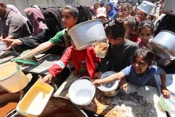 In coda per un pasto nel campo profughi di Nuseirat nella Striscia di Gaza