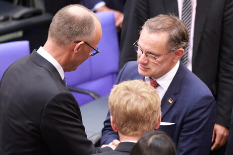 Alternative for Germany (AfD) party and faction co-chairman Tino Chrupalla (R) congratulates Merz