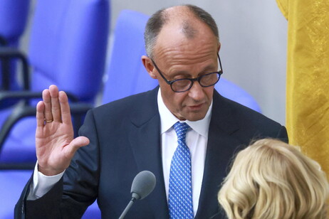 German Chancellor Friedrich Merz (L) takes the oath of office as he is sworn in by German Parliament