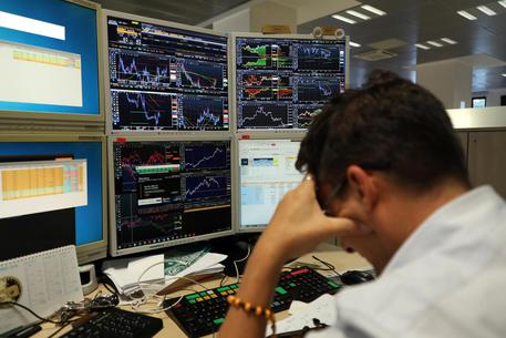 Un operatore di Borsa di una banca davanti ai monitor © ANSA