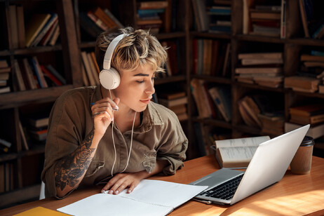 Una giovane donna studia ascoltando la musica foto iStock.