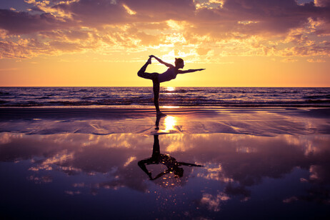 Una donna pratica yoga in spiaggia foto iStock.