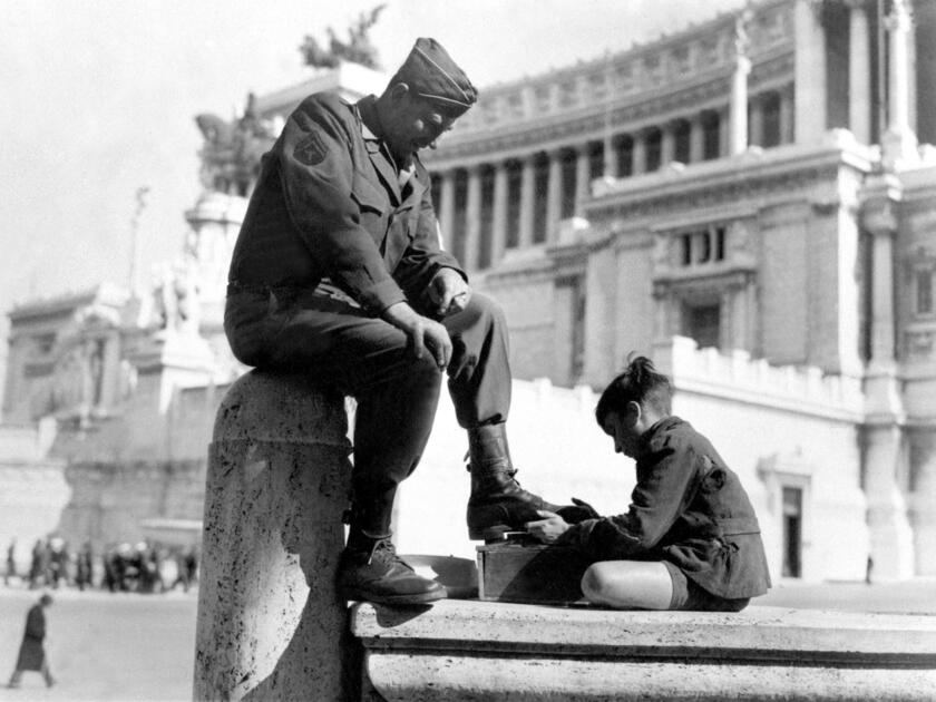 Uno sciuscia con un militare statunitense a piazza Venezia e Roma dopo la Liberazione avvenuta nel 1945