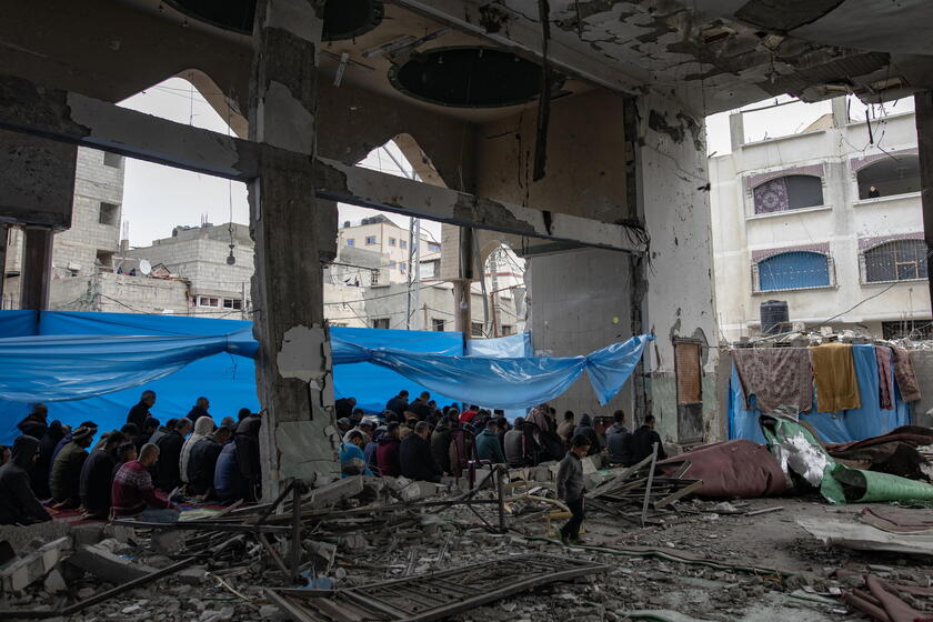 Palestinians perform Friday prayers in the ruins of Al-Huda Mosque © ANSA/EPA