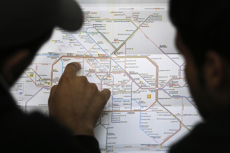 Due profughi siriani studiano la mappa dei trasporti pubblici di Berlino. © ANSA/AP