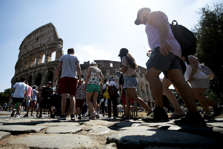 Turisti visitano il Parco archeologico del Colosseo e Fori Imperiali - RIPRODUZIONE RISERVATA