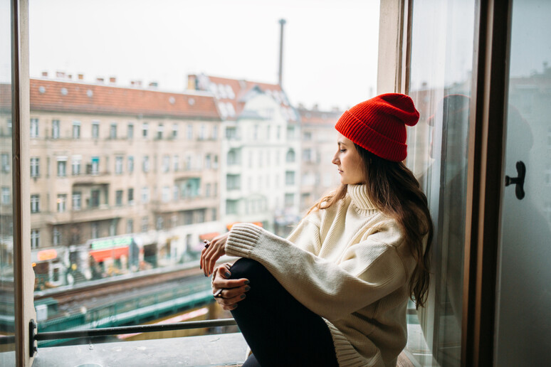 Una giovane donna con un maglione oversize e il berretto di lana foto iStock. -     RIPRODUZIONE RISERVATA