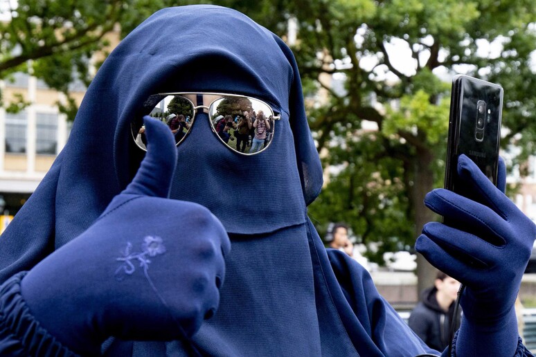 Una manifestante contro il divieto del burqa, archivio - RIPRODUZIONE RISERVATA