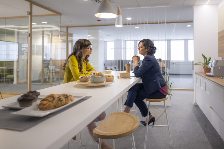 Due colleghe mangiano in ufficio foto iStock. - RIPRODUZIONE RISERVATA